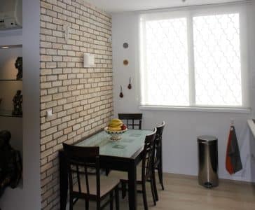 עיצוב דירה של אומן, פינת האוכל על רקע קיר לבנים ונישה, עיצוב פנים ופנג שואי, ענבל קרקו